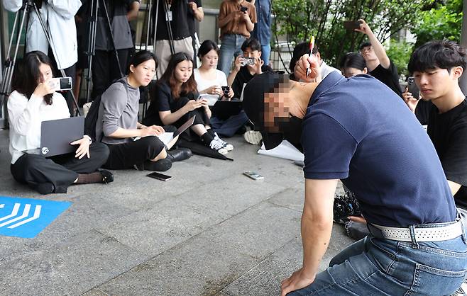 지난해 서울 강남역 의대생 살인 사건 피해자의 아버지가 20일 서울 서초경찰서에서 사체손괴 혐의로 가해자 최모씨를 고소한 뒤 취재진 앞에서 자신의 목과 얼굴에 사인펜으로 딸의 상흔을 표시하며 살해 과정을 직접 재연하고 있다. 연합뉴스
