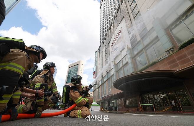 19일 서울 중구 롯데호텔에서 열린 을지연습 연계 통합방위능력 향상 관계기관 합동훈련에서 소방관들이 드론 테러 공격으로 인해 호텔에 화재가 발생한 상황을 가정해 화재진압 훈련을 하고 있다.