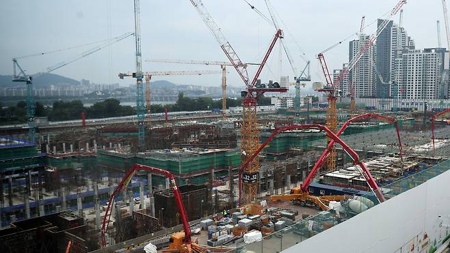 Cranes operate at an apartment construction site in Seoul on Aug. 11 as the government begins a crackdown on illegal subcontracting at construction sites. [YONHAP]