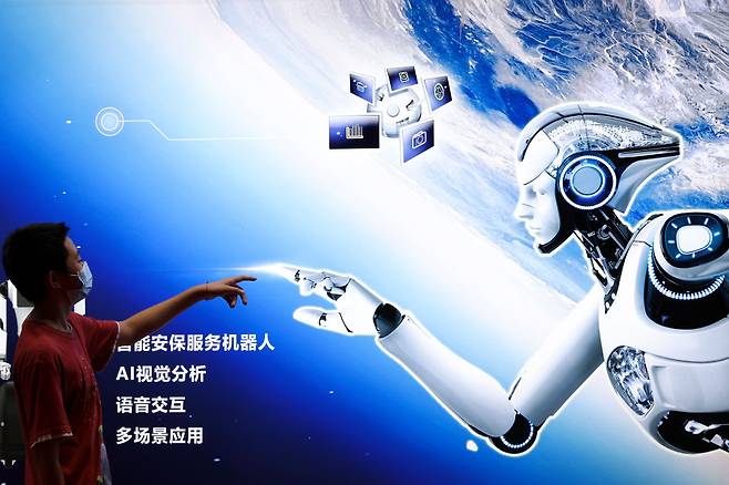 한 소년이 2022 세계 로봇 대회에서 AI 로봇 포스터를 가리키고 있다. [게티이미지]