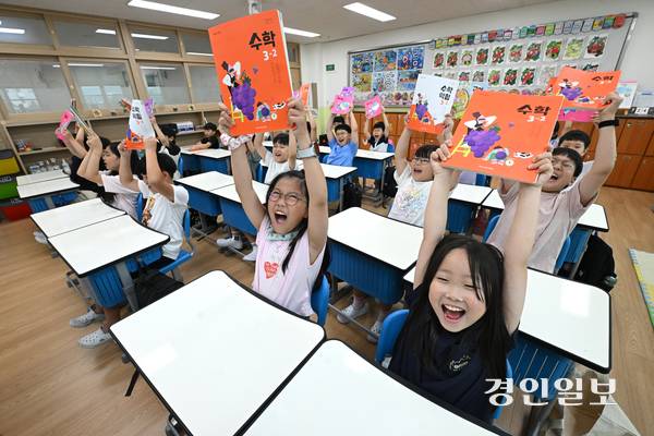 20일 오전 수원시 팔달구 매산초등학교에서 여름방학을 마치고 개학한 3학년 학생들이 교과서를 들어 보이며 환하게 웃고 있다. 2025.8.20 /최은성기자 ces7198@kyeongin.com