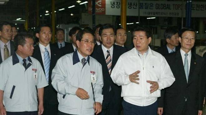 ▲ 2003년 7월 28일 고(故) 노무현(오른쪽 두번째) 전 대통령이 우수 수출기업 대우일렉의 인천공장을 시찰하면서 김충훈(왼쪽 두번째)사장과 대화를 하고 있다. /사진출처=노무현사료관
