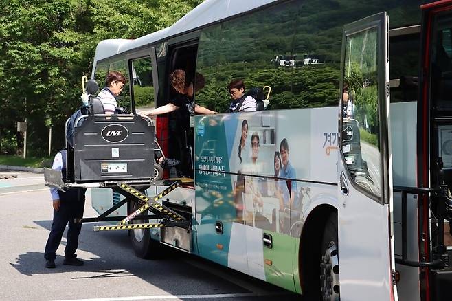 ▲ 경기도의 관광약자 무장애관광 코스개발 시범투어 사진. 휠체어 이용 참가자가 리프트를 이용해 버스에 승차하고 있다./사진제공=경기관광공사