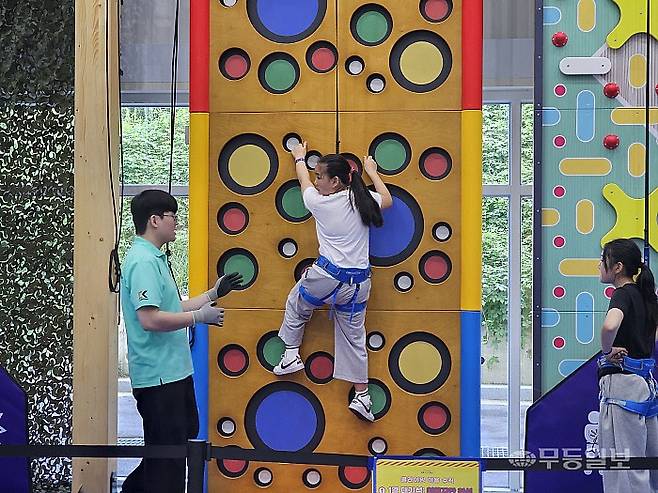 안전요원의 안내에 따라 어린이 체험객이 '디자인 암벽' 코스를 오르는 모습.