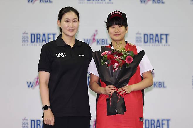 20일 오후 경기 부천시 부천체육관에서 열린 여자프로농구(WKBL) 2025~2026 신인선수 드래프트에서 1라운드 2순위로 BNK 썸에 지명된 온양여고 이원정이 박정은 감독과 기념촬영을 하고 있다. /뉴시스