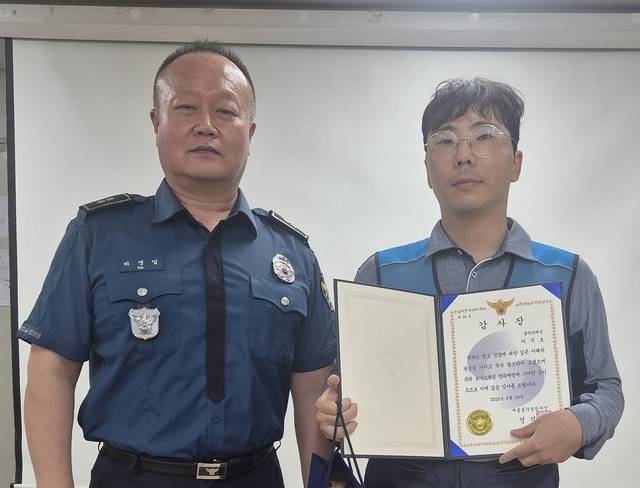 이석호 서울동작우체국 집배원(오른쪽)이 19일 보이스피싱 범죄예방 기여 공로로 하영일 서울남성지구대장에게 감사장을 받고 기념 촬영을 하고 있다. 서울지방우정청 제공