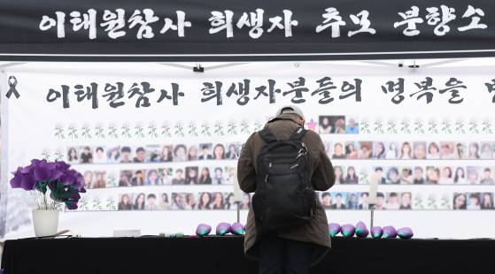 이태원 참사 2주기인 지난해 10월 대구 중구 동성로에 마련된 이태원 참사 희생자 추모 분향소에서 한 시민이 헌화 후 묵념하고 있다. 연합뉴스