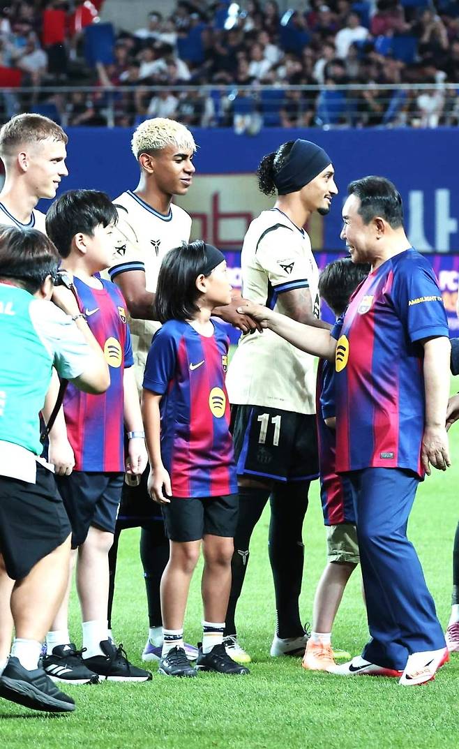 지난 31일 서울월드컵경기장에서 열린 FC바르셀로나 대 FC서울의 경기 시작 전, 제너시스BBQ그룹 윤홍근 회장이 선수들과 악수를 나누고 있다. [사진제공 제너시스BBQ그룹]