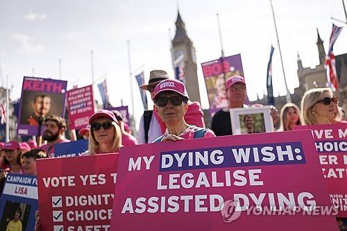 2025년 6월13일 영국 런던에서 조력사망 지지자들이 말기환자 조력사 허용법안에 대한 찬반시위 중 플래카드를 들고 있다.[EPA=연합뉴스 자료사진, 재판매 및 DB금지]