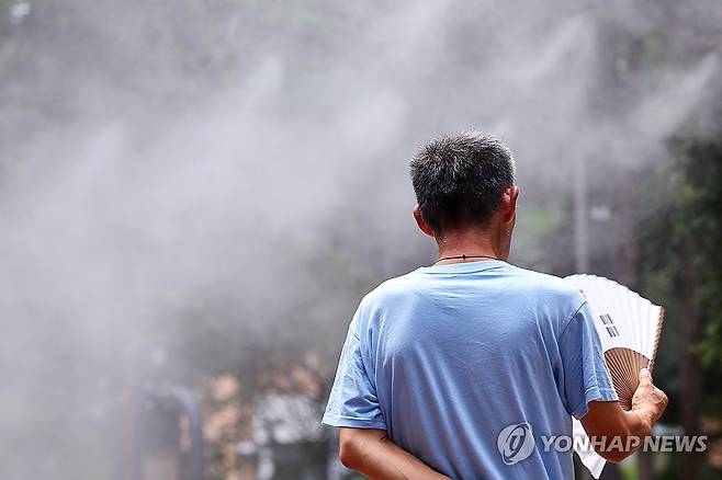 쿨링포그 속 부채질 [연합뉴스 자료사진]
