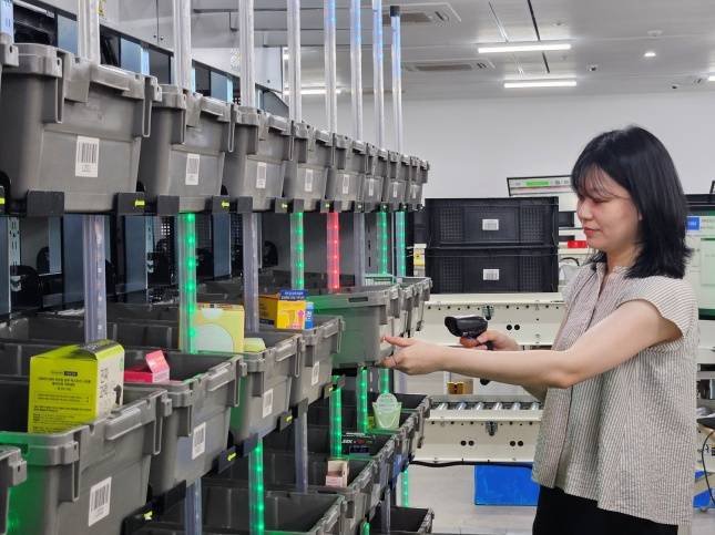 직원이 아이봇이 분류한 상품을 확인하고 있다./사진=올리브영