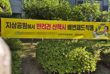 지상 공원에서 반려견 산책 시 배변패드 착용을 권장하는 현수막(독자 제공). ⓒ 뉴스1