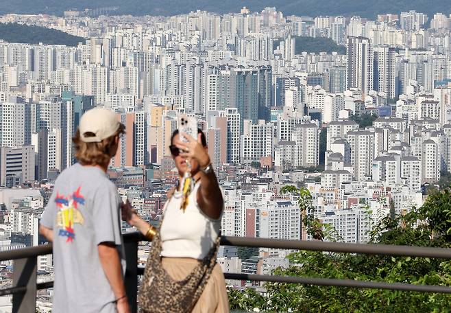 Tourists view Seoul from Mount Namsan in central Seoul on Aug. 21. [YONHAP]