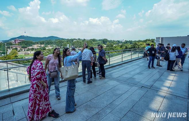 21일 서울 용산구 국립중앙박물관에서 외국인 관광객들이 남산을 배경으로 기념사진을 촬영하고 있다.