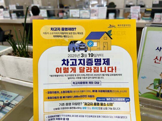 제주시 연동 주민센터에서 19일 한 시민이 차고지 증명제 안내문을 들고 있다.