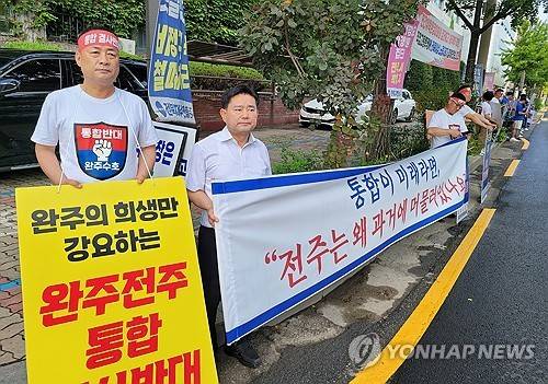 "완주·전주 통합 결사반대" (전주=연합뉴스) 김동철 기자 = 윤수봉 전북자치도의원(왼쪽 두 번째)과 완주군의원 11명 전원, 완주·전주 통합 반대 단체 회원 등 40여명이 21일 전주시청 앞에서 완주·전주 통합 반대 집회를 열고 있다. 2025.8.21