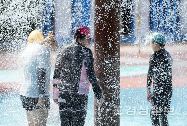 22일 울산지역 낮 최고 기온이 35℃로 오르는 등 폭염이 이어지고 있는 가운데 울산 중구 동천 야외물놀이장을 찾은 시민들이 물줄기를 맞으며 더위를 식히고 있다. 김도현기자 do@ksilbo.co.kr