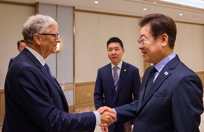 이재명 대통령(오른쪽)이 21일 용산 대통령실에서 빌 게이츠 게이츠재단 이사장(왼쪽)과 만나 악수를 하고 있다. 가운데가 이 대통령의 '1호 통역'인 조영민 외교부 서기관이다. /대통령실