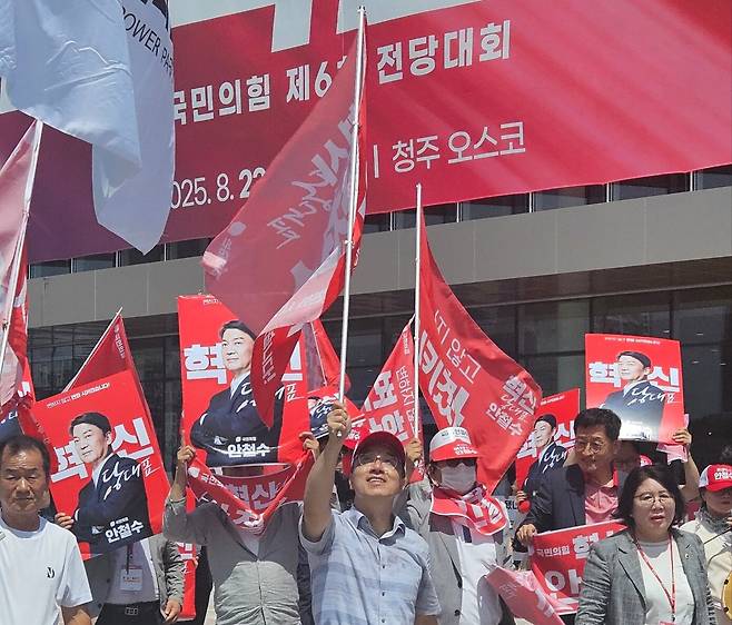 안철수 국민의힘 당대표 후보 지지자들이 22일 전당대회가 열린 충북 청주오스코 앞에서 깃발과 피켓을 들고 행진하고 있다./송복규 기자
