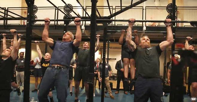 18일(현지 시간) 피트 헤그세스 미국 국방부 장관(45·오른쪽)과 로버트 F 케네디 주니어 보건복지부 장관(71)이 국방부 체력단련실에서 군 장병들과 함께 턱걸이를 하고 있다. 유튜브 채널 ‘Department of Defense’ 영상 갈무리