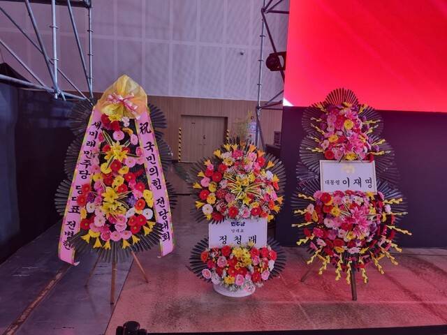 국민의힘 전당대회가 열리는 충북 청주 오스코 행사장에 이재명 대통령, 정청래 더불어민주당 대표, 전병헌 새미래민주당 대표가 보낸 축하 화환이 놓여있다. 전광준 기자