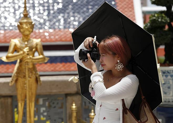 태국 방콕에 있는 한 유명 사원에서 관광객이 사진을 찍고 있다. [EPA]
