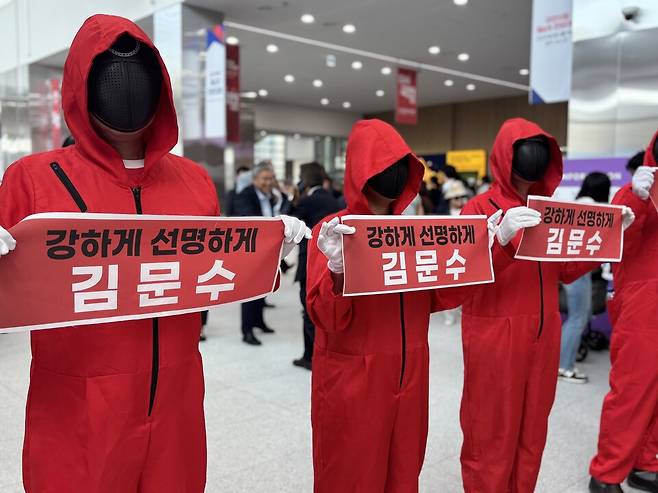 22일 충북 청주 오스코에서 열린 국민의힘 전당대회에서 김문수 후보 지지자들이 가면과 정장을 착용한 채 '강하게 선명하게 김문수'라는 피켓을 들고 응원하고 있다. ⓒ 시사저널 정윤경