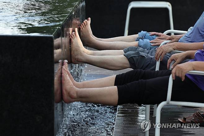 오늘도 무더위 (서울=연합뉴스) 서대연 기자 = 서울 한낮 기온이 33도까지 오르며 더운 날씨를 보인 21일 서울 종로구 광화문광장에서 시민들이 흐르는 물이 발을 대고 있다. 2025.8.21 dwise@yna.co.kr