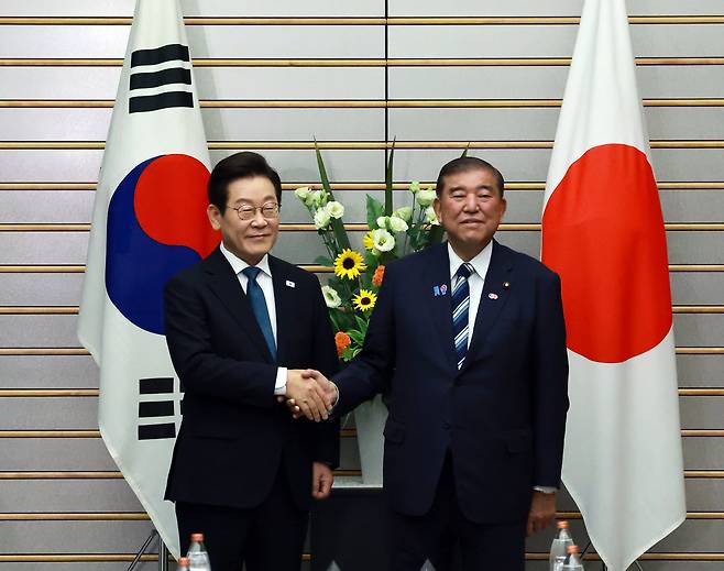 이재명 대통령과 이시바 시게루 일본 총리가 23일 일본 도쿄 총리 관저에서 열린 한일 확대정상회담에 앞서 기념촬영을 하며 악수하고 있다. /연합뉴스