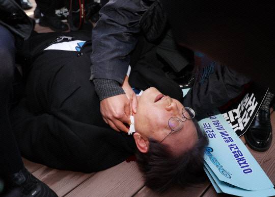 이재명 대통령이 더불어민주당 대표이던 지난해 1월 2일 오전 부산 가덕도 신공항 부지를 둘러 본 후 피습을 당해 쓰러지자 수행원들이 손수건으로 급히 지혈을 하고 있는 모습. 연합뉴스
