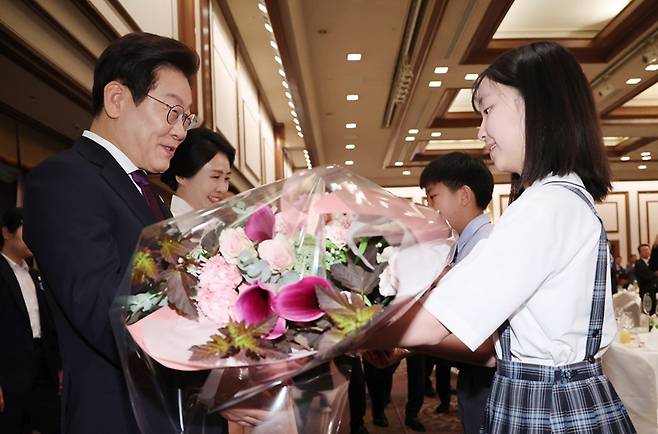 이재명 대통령과 김혜경 여사가 23일 일본 도쿄의 한 호텔에서 열린 재일동포 오찬 간담회에 참석해 화동으로부터 꽃다발을 받고 있다. 2025.8.23(사진=저작권자(c) 연합뉴스, 무단 전재-재배포 금지)