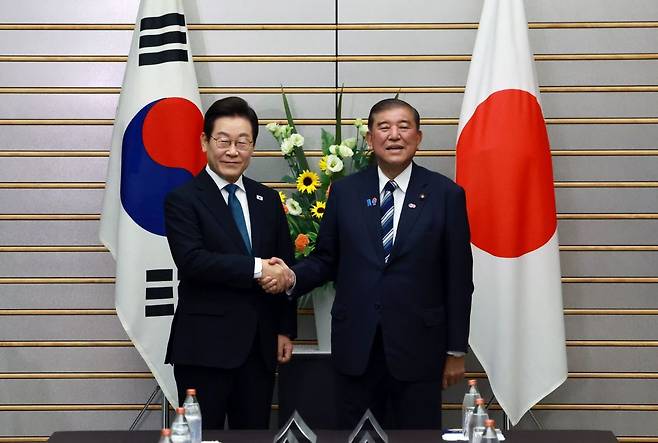 이재명 대통령과 이시바 시게루 일본 총리가 23일 일본 도쿄 총리 관저에서 열린 한·일 확대정상회담에 앞서 기념촬영을 하며 악수하고 있다. 연합뉴스