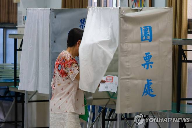 대만 야당 의원 파면투표 및 원전 재가동 국민투표 (타이베이 EPA=연합뉴스) 23일 대만 타이베이에서 한 유권자가 친중 성향 야당 의원들에 대한 파면투표와 원전 재가동 국민투표에 참여하고 있다. 2025.8.23