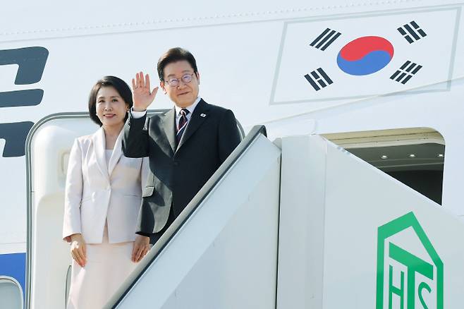 일본 방문 일정을 마친 이재명 대통령과 김혜경 여사가 23일 도쿄 하네다공항에서 도널드 트럼프 미국 대통령과의 한미 정상회담을 위해 워싱턴DC로 향하며 공군1호기에 올라 인사하고 있다. /뉴시스