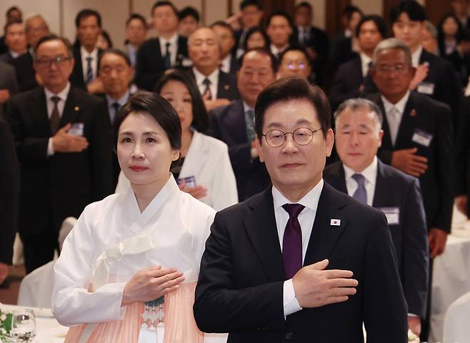 이재명 대통령과 김혜경 여사가 23일 일본 도쿄의 한 호텔에서 열린 재일동포 오찬 간담회에서 국기에 경례하고 있다. 연합뉴스