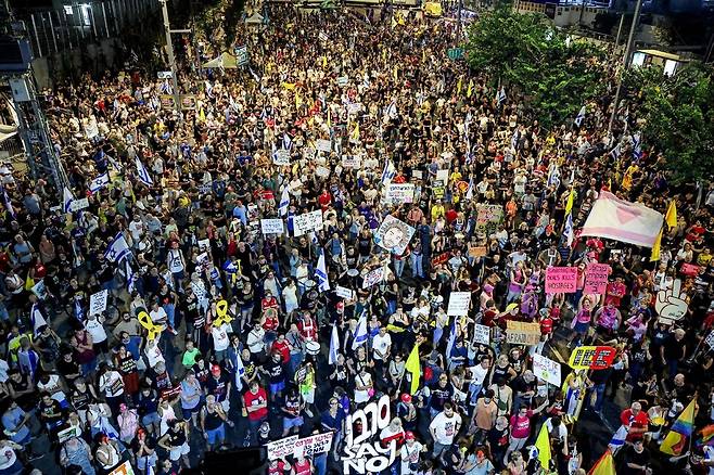 23일(현지시각) 이스라엘 텔아비브에 있는 국방부 건물 밖에서 인질 가족들이 주최한 시위에 참여한 시위대가 인질 석방 보장과 휴전을 요구하고 있다. AFP 연합뉴스