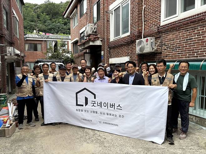 주광덕(앞줄 오른쪽 네 번째) 남양주시장과 김한원(두 번째) 빛과소금교회 목사를 비롯해 봉사자, 지자체 관계자들이 23일 경기도 남양주 다세대 주택에서 집 수리 마무리 공사를 마치고 기념 촬영을 하고 있다.