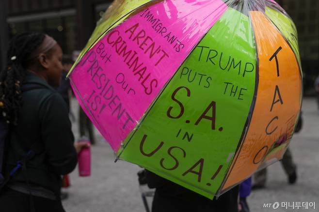 지난달 17일(현지 시간) 미 일리노이주 시카고 데일리 광장에서 열린 ‘선한 소란은 계속된다’(Good Trouble Lives On) 전국 행동의 날 집회에서 한 시위자가 반트럼프 문구가 적힌 우산을 들고 있다. ‘선한 소란’은 2020년 7월 17일 타계한 미국의 인권운동가이자 하원의원이었던 존 루이스가 만든 표현으로, 부당함에 맞서 의미 있는 변화를 이루기 위해 평화롭고 비폭력적인 방식으로 함께 행동하는 것을 뜻한다. /AP=뉴시스