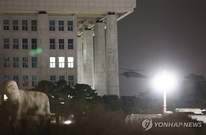 비상계엄의 밤 (서울=연합뉴스) 신현우 기자 = 2024년 12월 3일 밤 윤석열 당시 대통령이 비상계엄을 선포한 가운데 여의도 국회의사당 방향으로 헬기가 날아가고 있다. [연합뉴스 자료사진]