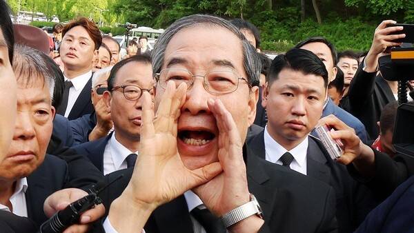지난 5월 광주 북구 국립 5·18 민주묘지를 찾은 한덕수 전 총리가 광주비상행동 등 시민·사회단체 관계자들의 반발에 가로 막히자 "저도 호남 사람"이라며 참배를 호소하고 있다. 연합뉴스