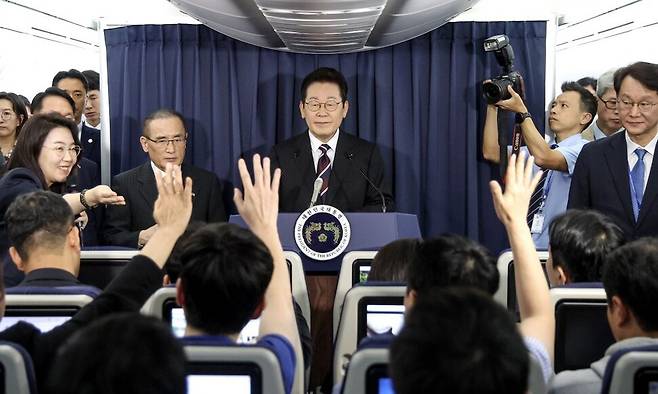 이재명 대통령이 24일(현지시간) 일본 도쿄 하네다공항 이륙 뒤 한미 정상회담을 위해 미국 워싱턴DC로 향하는 공군 1호기 기내에서 기자간담회를 하며 취재진의 질문을 받고 있다. 공군1호기/연합뉴스