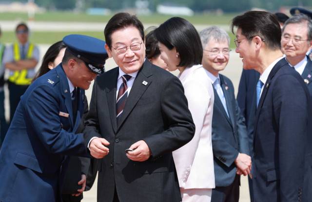 ▲ 취임 후 처음 미국을 방문한 이재명 대통령이 24일(현지시간) 미국 워싱턴DC 인근 앤드루스 합동기지에 도착해 공군1호기에서 내려 영접 인사로 나온 미국 측 조슈아 킴 대령으로부터 기지 방문 기념 코인을 받아 들고 있다. 연합뉴스