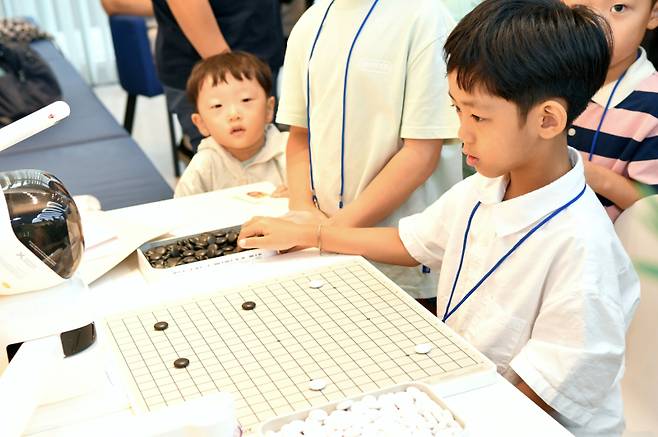 체험 부스에서 AI 바둑 로봇과 대국하는 어린이. 한국기원 제공