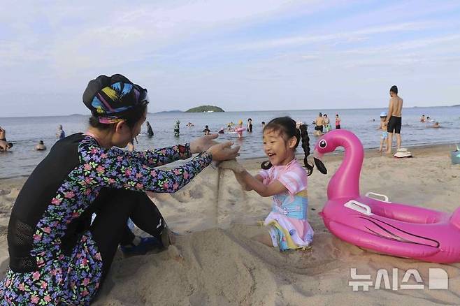 [원산=AP/뉴시스] 지난달 1일 북한 강원도 원산의 원산-갈마 해안관광지구 해변에서 한 모녀가 모래놀이하고 있다. 2025.08.25.