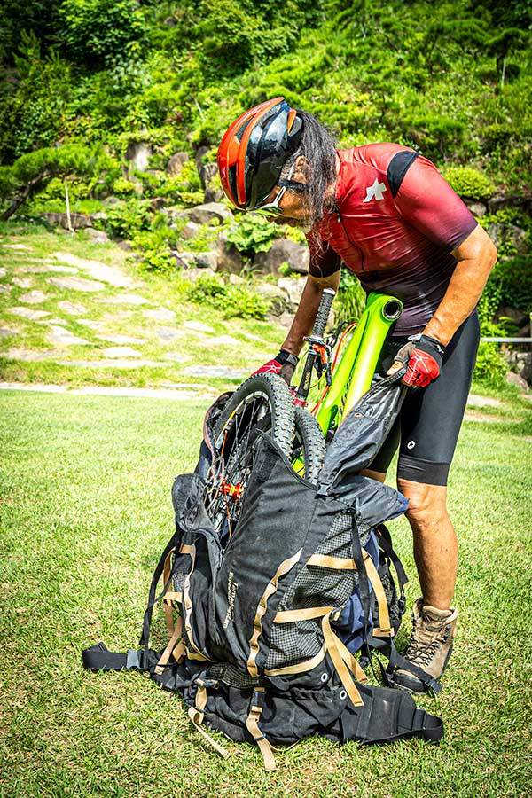 대형배낭을 직접 개조해 거의 150L에 달하는 초대형배낭을 만들어 분해한 자전거를 넣고 지고 다녔다.