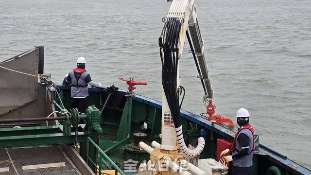 청항선 선원들이 26일 군산항 인근에서 해양 쓰레기를 발견하고 크레인을 조작하고 있다. 김문경 기자