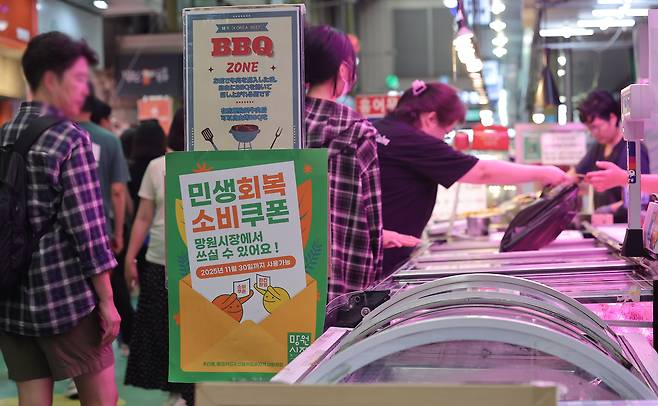 8월 24일 서울 마포구 망원시장에 민생회복소비쿠폰 홍보 안내문이 부착돼 있다./연합뉴스