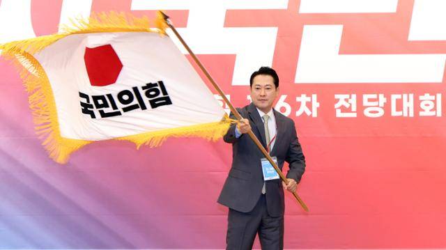 장동혁 국민의힘 신임 당대표가 26일 국회도서관에서 전당대회 승리를 확정 지은 뒤 당기를 흔들고 있다. 고영권 기자