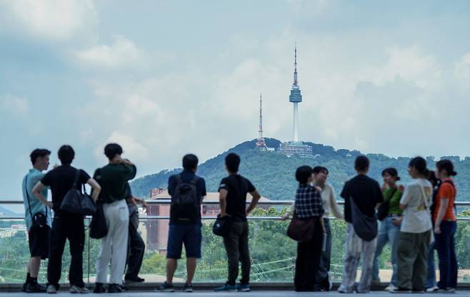 지난 21일 서울 용산구 국립중앙박물관에서 외국인 관광객들이 남산을 배경으로 기념사진을 찍고 있다. 유희태 기자