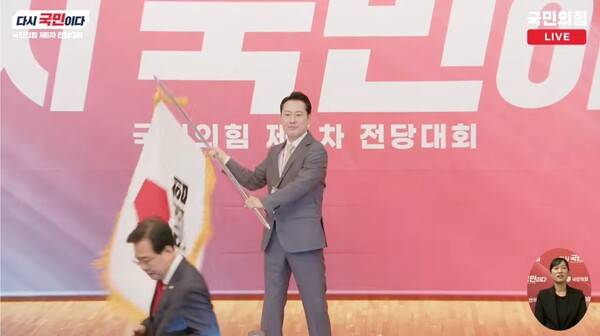 ▲장동혁 신임 국민의힘 대표가 26일 대표에 선출된 뒤 건네받은 당기를 흔들고 있다. 사진=국민의힘TV 영상 갈무리